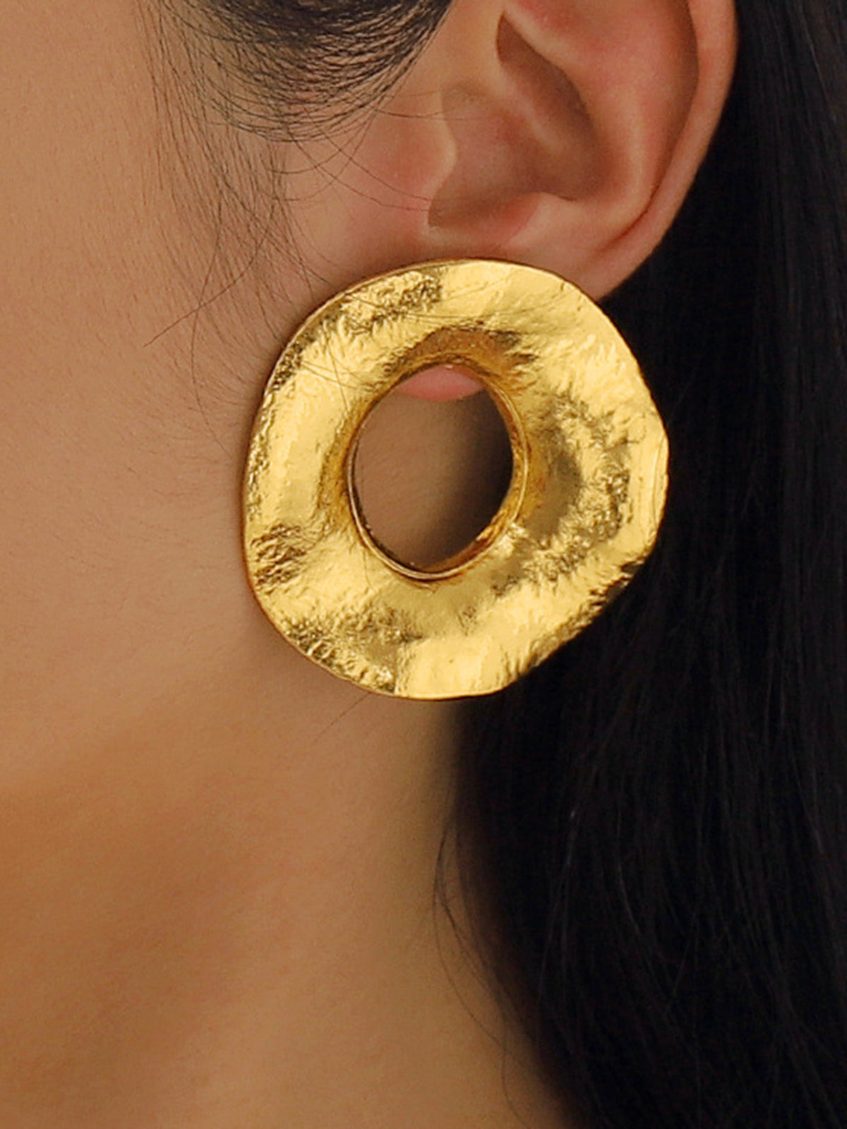 Round gold-colored metal earrings with texture for an elegant look