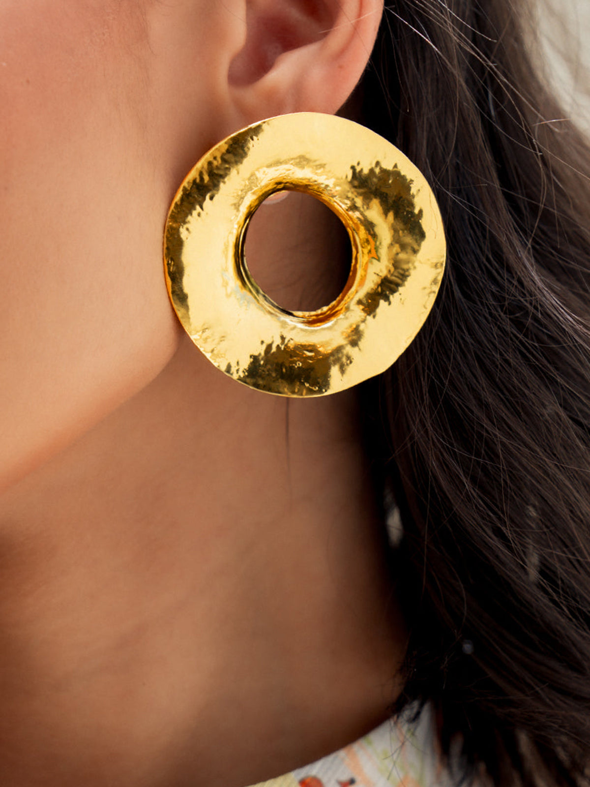 Round gold-colored metal earrings with texture for an elegant look