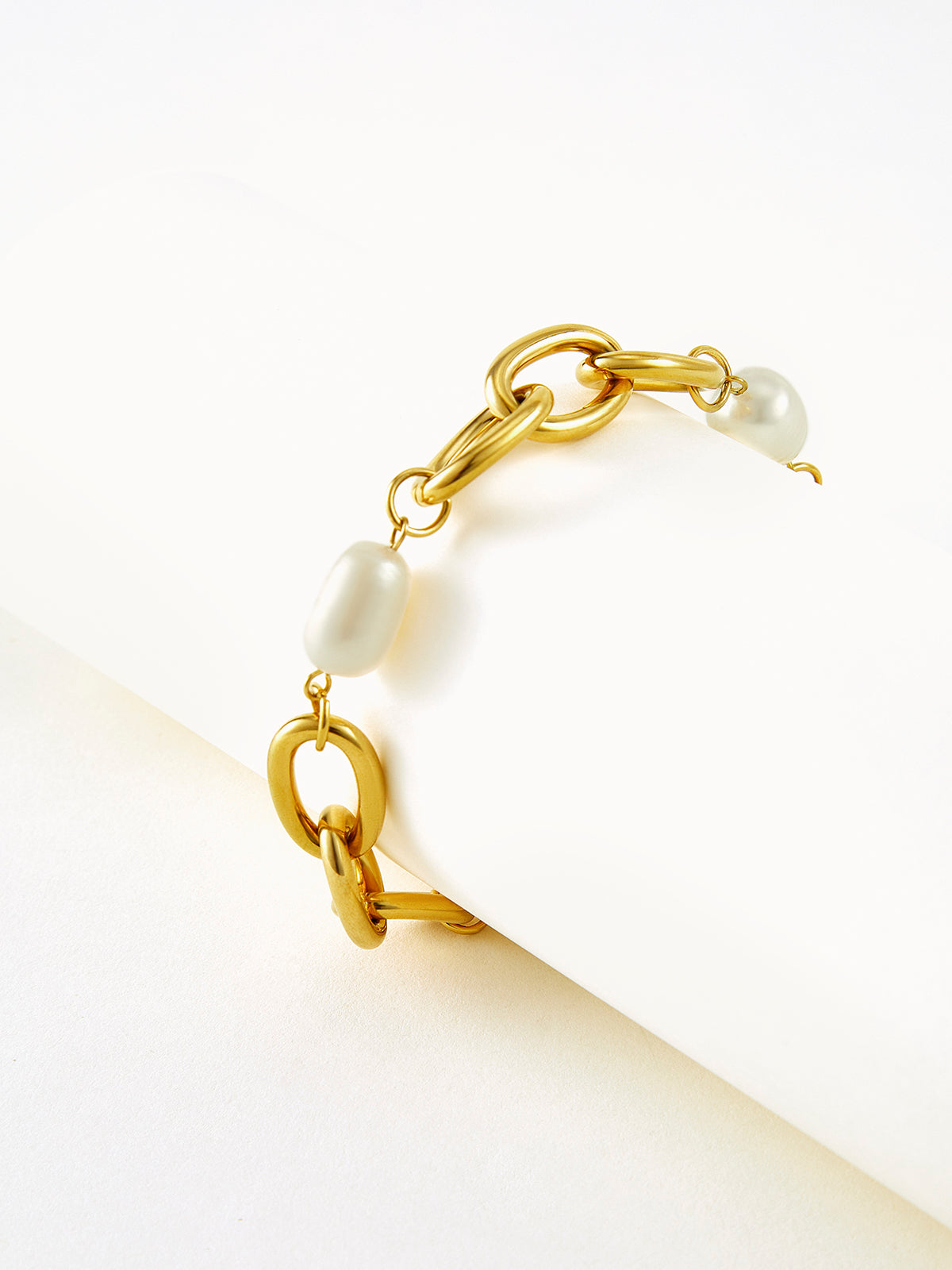 Elegant gold bracelet with chain links and oval pearls