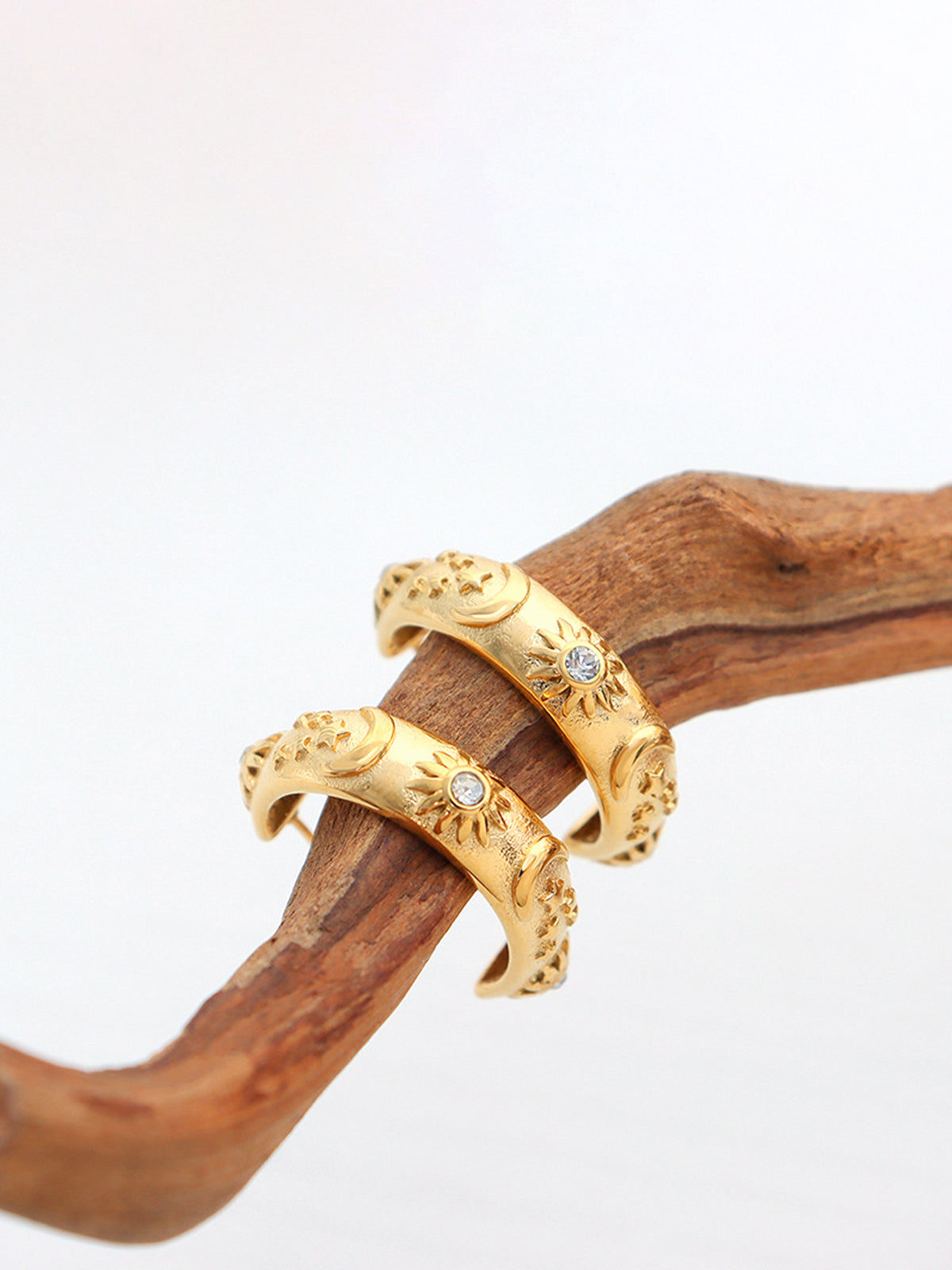 Creole earrings with relief motif and sparkling zirconia